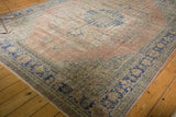 Distressed Oushak rug corner, faded dusty blush field with geometric cobalt blue border.