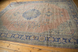 Distressed Oushak carpet border showcasing cobalt royal blue geometric vinery on pale blush.