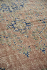 Distressed vintage Oushak rug texture with blush and cobalt geometric floral pattern.