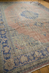Hand-knotted distressed Oushak rug corner with cobalt blue borders and faded blush vinery.