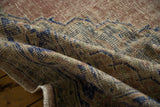 Distressed Oushak carpet pile texture with muted blush, beige, and striking cobalt blue pattern.