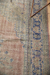 Distressed Oushak rug with faded blush, beige, and cobalt blue geometric vinery.