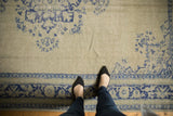 Distressed vintage Oushak carpet showing pale celadon green and faded cobalt blue patterns.