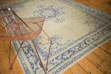 Distressed vintage Oushak rug corner showing faded celadon green and cobalt blue designs.