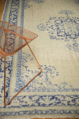 Distressed Oushak rug border, pale celadon green field with worn cobalt blue patterns.