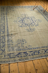 Worn pile of distressed Oushak rug, showing faded celadon and cobalt blue pattern.