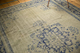 Distressed Oushak rug texture with worn pale celadon green and faded cobalt blue motifs.