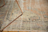 Close-up of distressed vintage Oushak rug, showing mostly even wear, apricot, and muted blue.