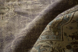 Textural folds of vintage distressed Oushak carpet in muted purple, slate blue, ivory tones.