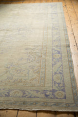 Distressed vintage Oushak main border with faded blue scrolling leaves and subtle field wear.