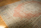 Faded blush terra cotta medallion and worn pile texture of a vintage Oushak rug.
