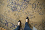 Textured distressed Oushak rug, faded pale ivory field with cobalt blue motifs.
