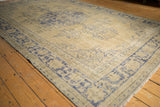 Textured vintage distressed Oushak carpet with faded cobalt blue and pale ivory motifs.