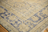 Distressed texture and faded cobalt blue geometric motifs on a vintage Oushak rug corner.