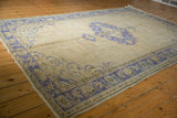 Distressed Oushak rug corner with faded cobalt blue palmette border and even pile wear.