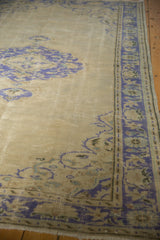 Distressed vintage Oushak carpet detail, faded cobalt blue palmette border, pale ivory field.