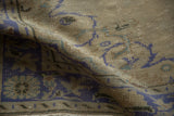 Faded ivory and cobalt blue curvilinear pattern on a distressed vintage Oushak rug.