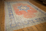 Blush red distressed Oushak rug texture, cobalt blue border, and worn foundation.