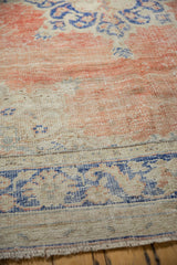 Distressed Oushak rug: blush red, cobalt blue border, worn knot heads, faint foundation, short fringe.