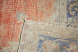 Distressed blush red and ivory Oushak rug pile showing visible foundation and weave.