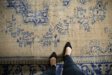 Distressed Oushak rug with heavy abrashes and faded cobalt blue motifs.