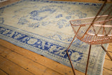 Decorative cobalt blue blossoms and palmettes on a distressed Oushak rug.