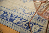 Distressed Oushak rug border, with faded cobalt blue and ivory floral palmettes.