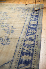Distressed vintage Oushak carpet border, featuring cobalt blue blossoms and dusty ivory abrashes.