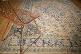 Decorative texture on distressed vintage Oushak rug, with faded apricot and cobalt blue motifs.