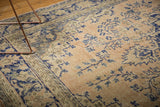 Distressed vintage Oushak carpet with pale rose apricot field and cobalt blue floral vinery.