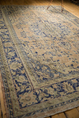 Close-up of the distressed Oushak rug's secure side, showing Rococo floral vinery with even wear.