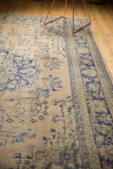 Distressed vintage Oushak texture showing faded cobalt blue patterns on pale apricot.