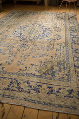 Distressed vintage Oushak carpet's secured edge, showing soft apricot, blue, and neutral tones.