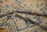 Distressed Oushak rug pile with faded beige, cobalt blue, and pale rose apricot tones.