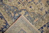Vintage distressed Oushak rug corner, showing worn pile, geometric contour, and hand-knotted foundation.