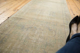 Distressed Oushak runner texture displaying mostly even wear through pale ivory, faded blue, green.