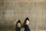 Distressed vintage Oushak runner showing geometric patterns in faded ivory and muted green.