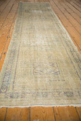 Close-up of distressed Oushak rug with mostly even wear, faint foundation, faded blue patterns.