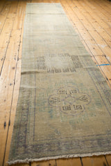 Secured fringe and textured pile of distressed Oushak runner in faded ivory, blue-green.