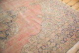 Vintage distressed Oushak corner: blush field, dusty navy, and ivory Rococo motifs.