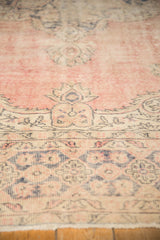 Distressed vintage Oushak pile featuring mostly even wear, pale blush, and dusty navy.