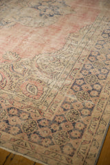 Distressed Oushak rug pile with faded blush, dusty navy, and ivory Rococo motifs.