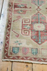 Textured pile and dusty red serrated border on a distressed Oushak rug corner.