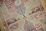 Distressed vintage Oushak rug's faded cochineal red and aqua blue scrolling motifs.