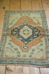 Distressed Oushak rug with faded copper rust and charcoal navy stepped medallion and floral motifs.