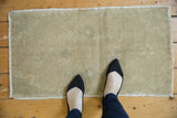 Vintage Oushak rug displaying muted beige tones, hand-knotted texture, and even distressed wear.