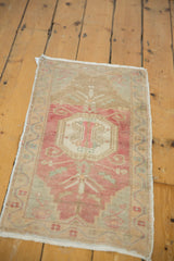 Softly faded vintage Oushak rug corner with pale pink, beige, and powder blue scrolling tendril motifs.