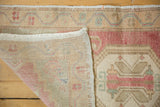 Vintage Oushak rug showing hand-knotted reverse and distressed pink, ivory, beige pile.