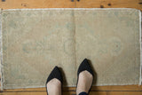 Vintage distressed Oushak rug with soft, faded ivory and pale seafoam green patterns.