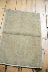Secured end with natural short fringe and worn pile texture of the Oushak mat.